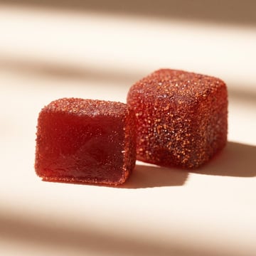 Two Spicy Cubes in close-up: one showing the chili-tamarind coating on all sides, the other cut to show the translucent interior