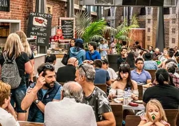 Friends talking at a busy outdoor restaurant