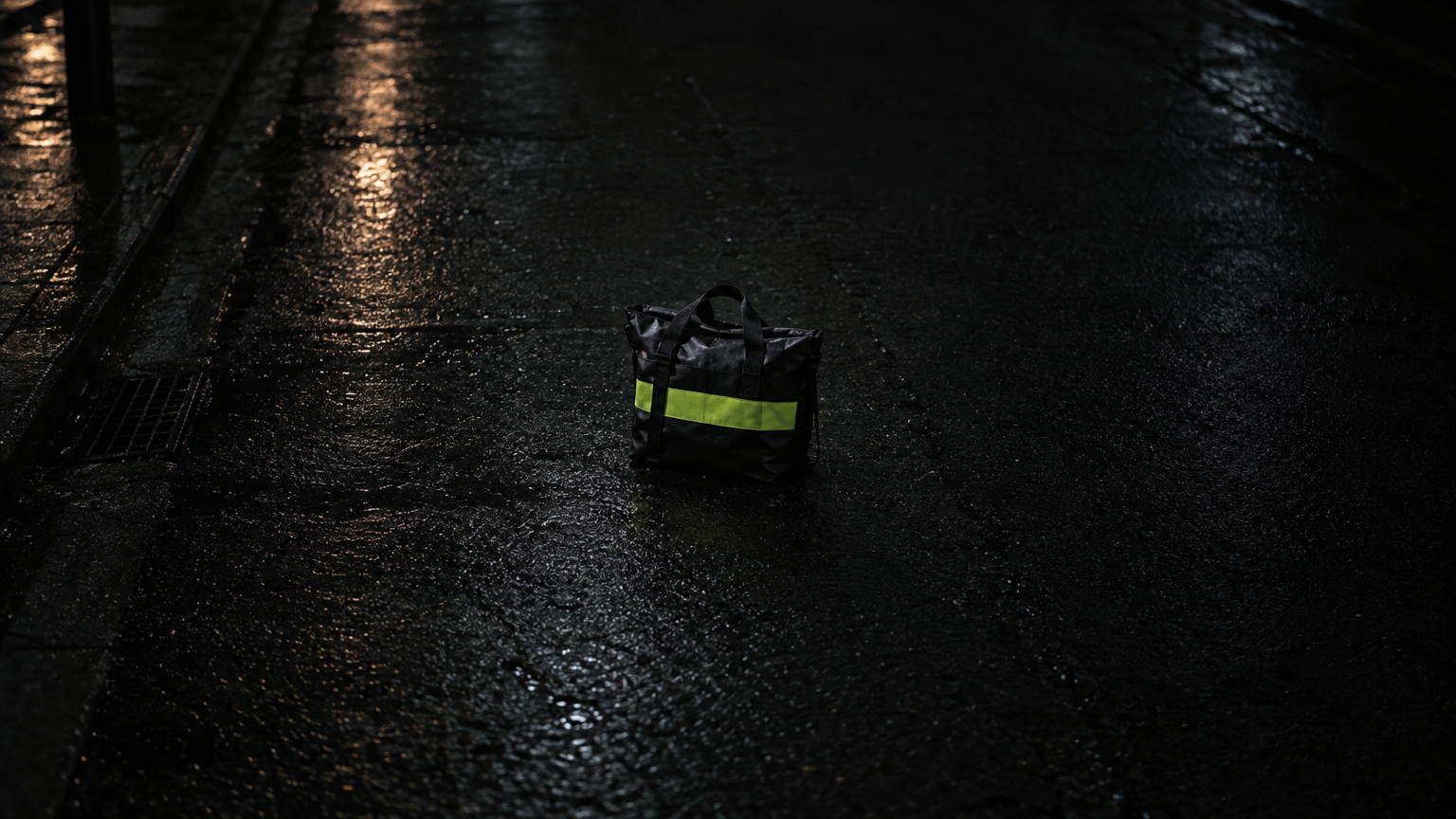 A Zip Mart courier bag on wet asphalt at night