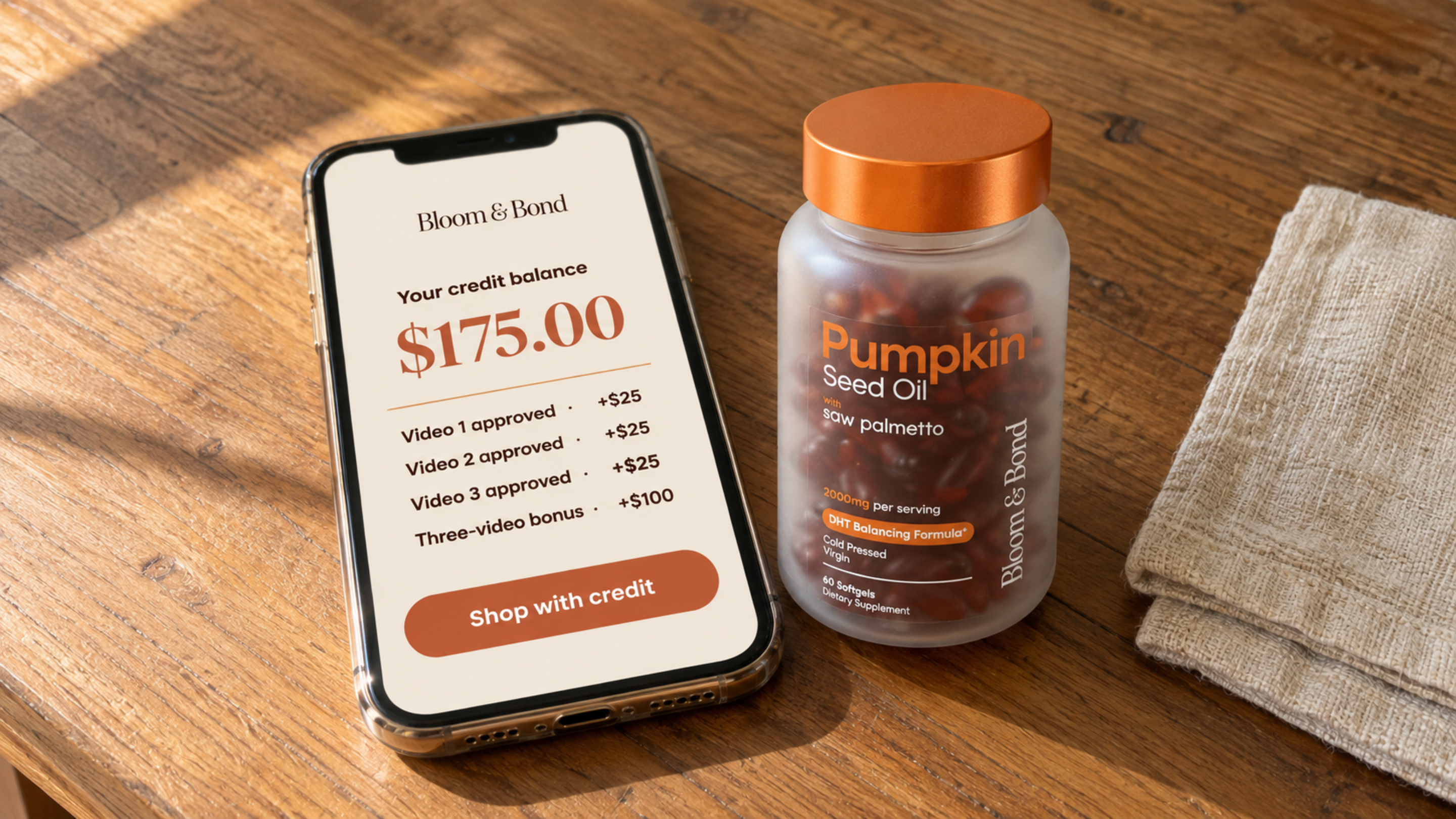 A smartphone showing a credit balance next to a bottle of pumpkin seed oil supplements on a table.