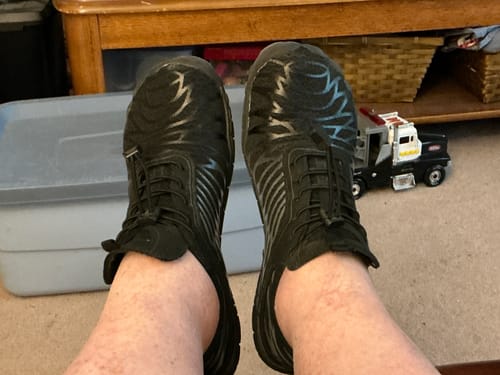 Customer wearing their black Lorax Pro barefoot shoes while relaxing with feet up.