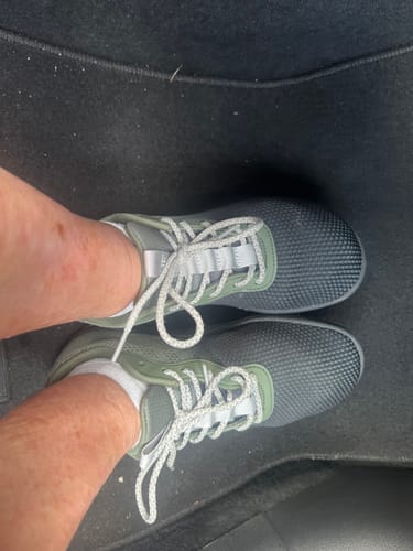 Customer's feet wearing Lorax Pro barefoot shoes in a soft grey and green design with white laces.