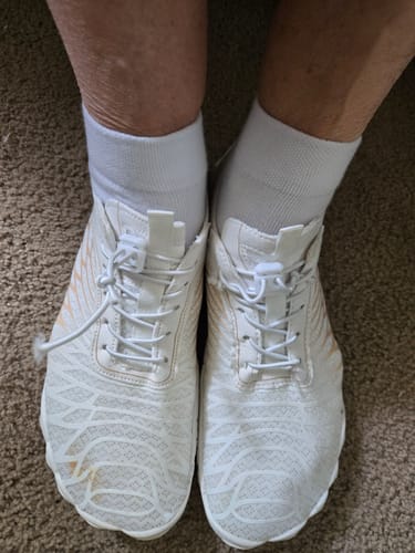 Customer's feet in white, wide-toed Lorax Pro barefoot shoes