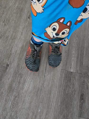 Customer's Lorax Pro barefoot shoes worn on feet with blue socks, standing on wooden flooring.