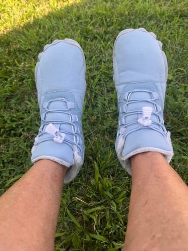Customer's light blue Lorax Pro barefoot shoes with fuzzy lining, worn outdoors on green grass.