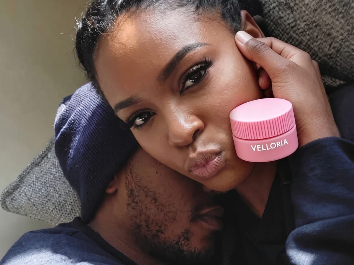 A woman holding a pink Velloria mini lip mask jar